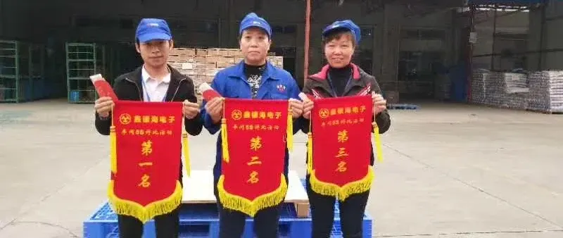 Three Xinyinhai employees holding the company’s internal workplace-review pennants