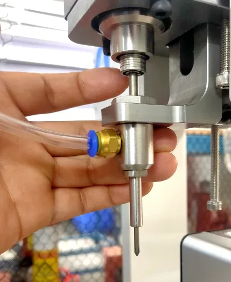 Hands showing the screw-machine suction nozzle and driver bit assembly