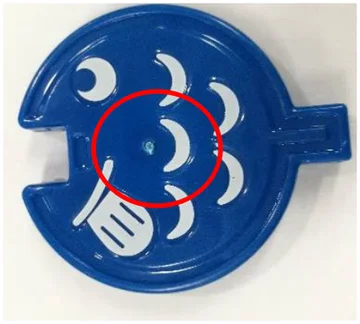 Ejector-related whitening. The circle identifies the whitened area on the blue molded part.