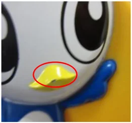 Scratch in the painted finish. The ellipse marks the scratch on the yellow painted area.
