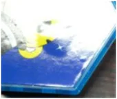 Bubbles under a label. The source identifies bubbling on the labeled surface. The original image has limited detail.