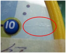 Wrinkled label. The ellipse identifies a wrinkle in the label.