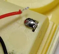 Poor wire-soldering training example showing a red wire separated from its soldered contact