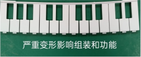 A row of molded white keys bows noticeably; the source identifies severe deformation affecting assembly and functionality.